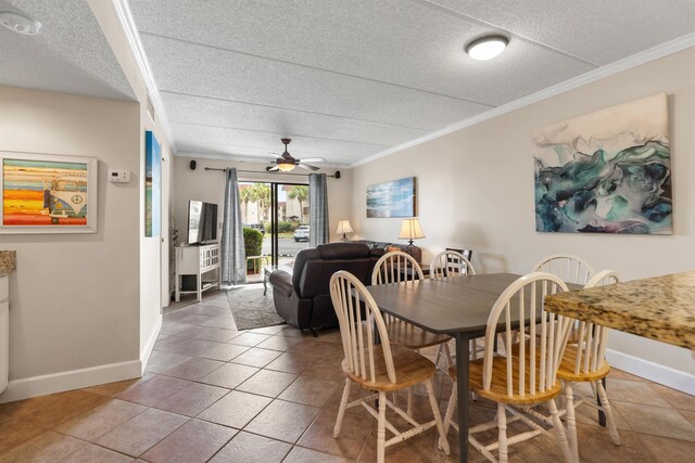 tiled dining area featuring a textured ceiling, ceiling fan, and crown molding