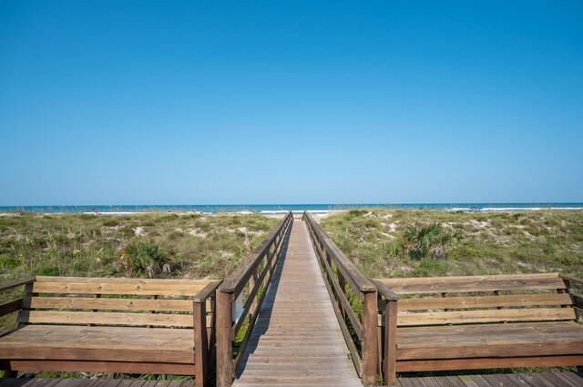 view of property's community with a beach view and a water view