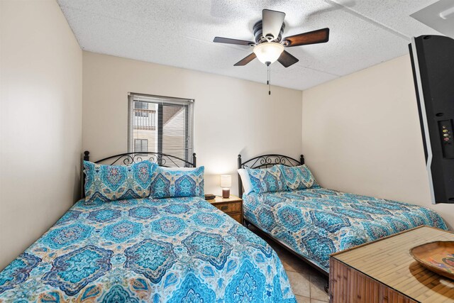 bedroom with light tile patterned floors, a textured ceiling, and ceiling fan