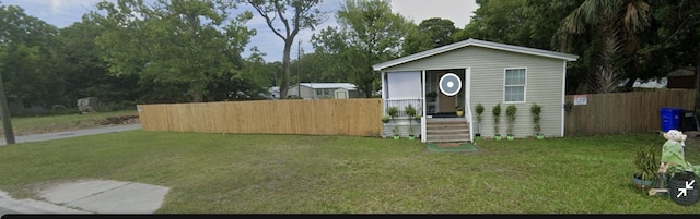 view of front facade featuring fence and a front lawn