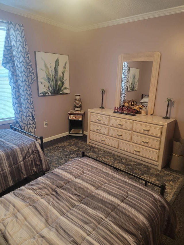 bedroom featuring crown molding, baseboards, and dark colored carpet