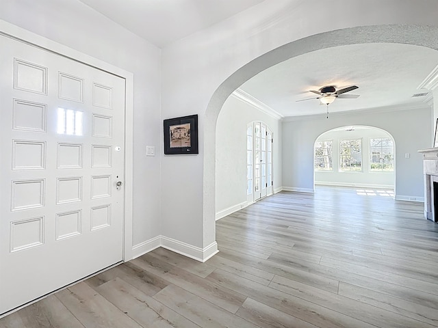 307 Minorca Ave, Saint Augustine, FL 32080 - foyer with baseboards, arched walkways, a fireplace, and light wood finished floors