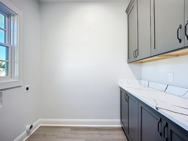 307 Minorca Ave, Saint Augustine, FL 32080 - washroom featuring cabinet space, baseboards, hookup for an electric dryer, and light wood-type flooring