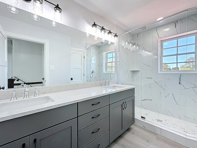 307 Minorca Ave, Saint Augustine, FL 32080 - full bath featuring double vanity, wood finished floors, a marble finish shower, and a sink