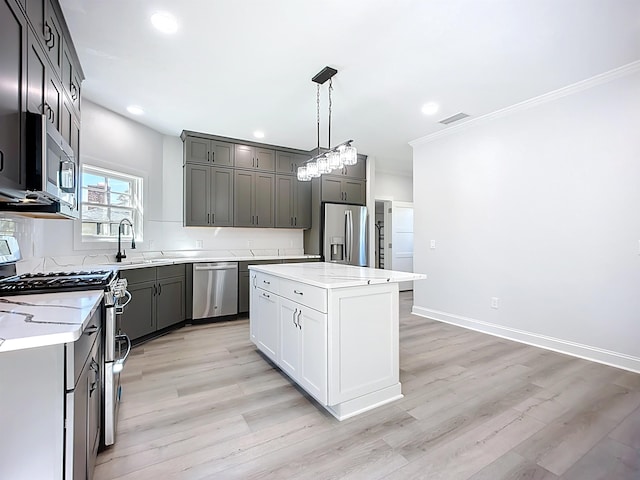 307 Minorca Ave, Saint Augustine, FL 32080 - kitchen with decorative light fixtures, a center island, stainless steel appliances, light wood-style floors, and baseboards