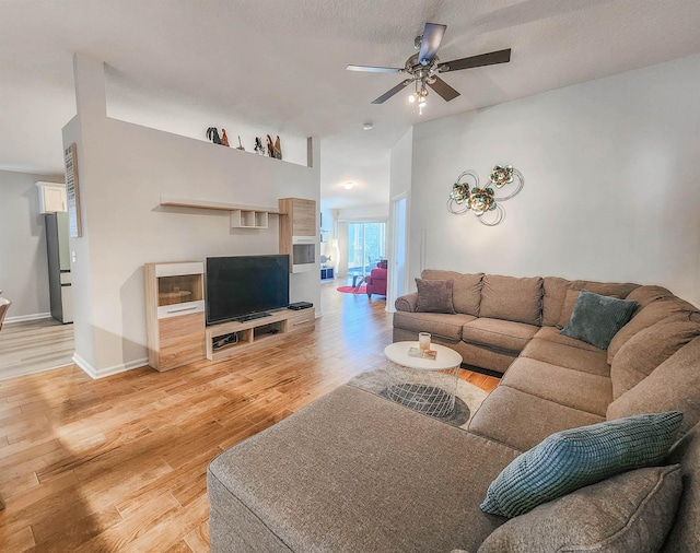 living room featuring ceiling fan, hardwood / wood-style floors, and a textured ceiling