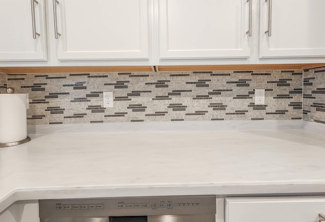 details featuring white cabinets, tasteful backsplash, and dishwashing machine