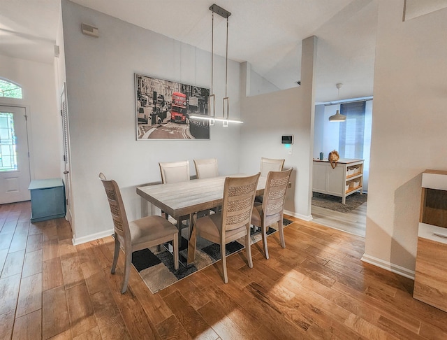 dining space featuring vaulted ceiling and hardwood / wood-style flooring