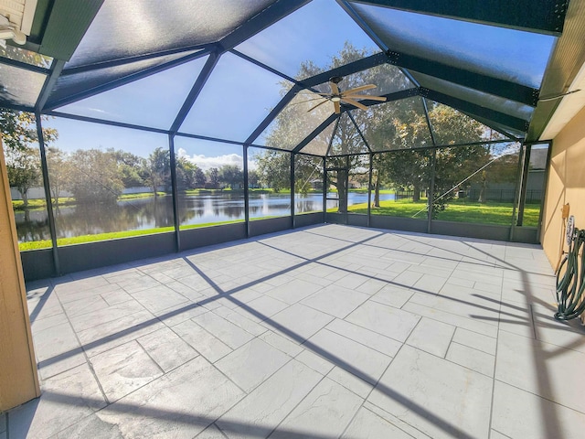 view of patio with glass enclosure and a water view