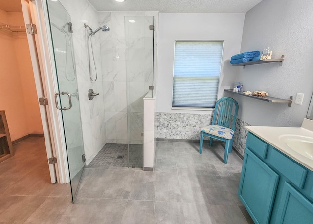 bathroom with vanity, a textured ceiling, walk in shower, and tile patterned flooring