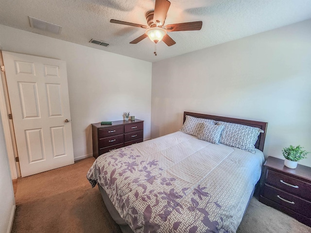 carpeted bedroom featuring a textured ceiling and ceiling fan