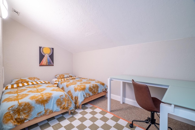 carpeted bedroom featuring vaulted ceiling, baseboards, a desk, and a textured ceiling