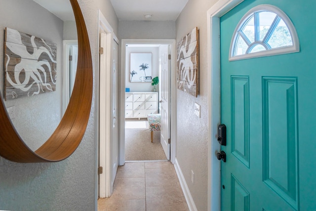 foyer featuring light tile patterned floors and baseboards