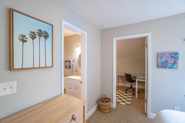 hall with a desk, carpet floors, and baseboards
