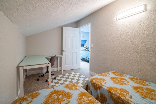 carpeted bedroom featuring lofted ceiling, a textured wall, a textured ceiling, a desk, and baseboards