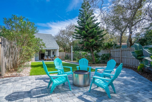 view of patio with a fenced backyard, an outdoor fire pit, and an outdoor structure