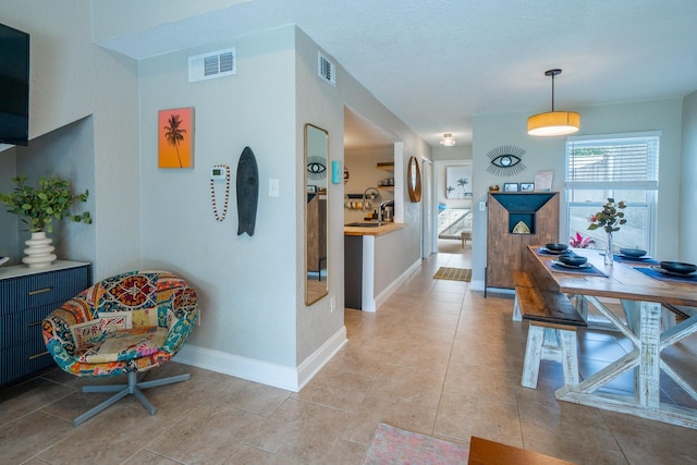 corridor with baseboards and light tile patterned flooring