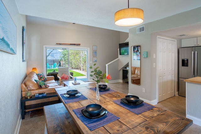 dining room with baseboards and stairway