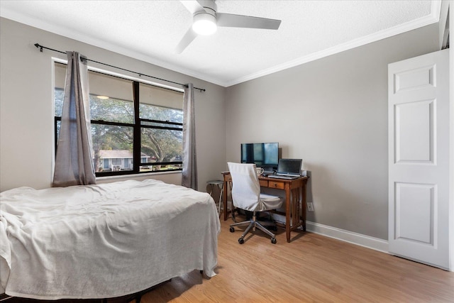 bedroom with ceiling fan, light hardwood / wood-style flooring, a textured ceiling, and ornamental molding