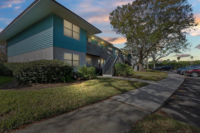 property exterior at dusk featuring a yard