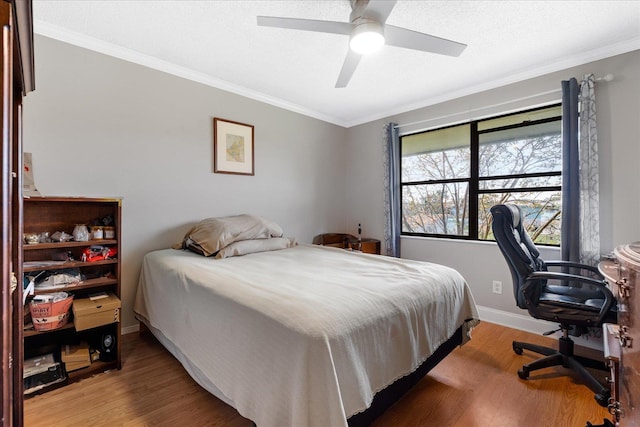 bedroom featuring ceiling fan, wood-type flooring, and crown molding