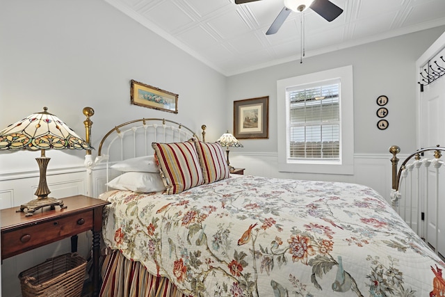 bedroom with wainscoting, a ceiling fan, and crown molding