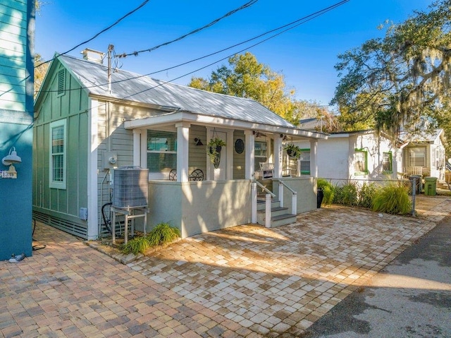 bungalow-style home with central air condition unit