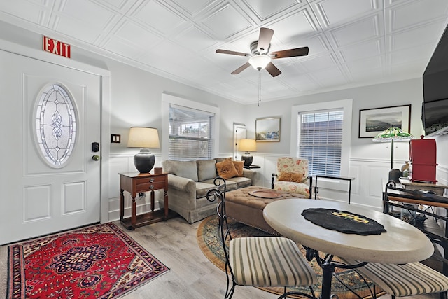 foyer featuring an ornate ceiling, a wainscoted wall, light wood-style flooring, and ceiling fan