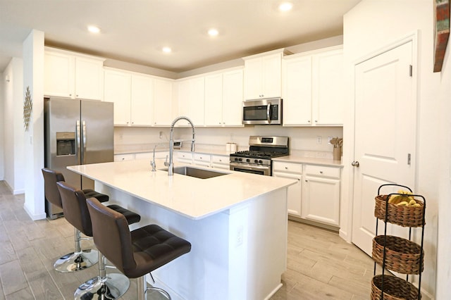 kitchen featuring white cabinets, sink, an island with sink, and appliances with stainless steel finishes