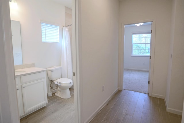 bathroom with vanity, a shower with shower curtain, and toilet