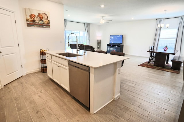 kitchen featuring dishwasher, sink, light wood-type flooring, and an island with sink