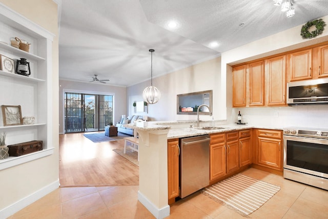 kitchen with sink, light tile patterned floors, a textured ceiling, and appliances with stainless steel finishes