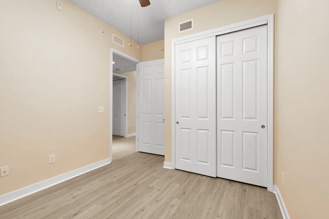 unfurnished bedroom featuring ceiling fan, light wood-type flooring, and a closet