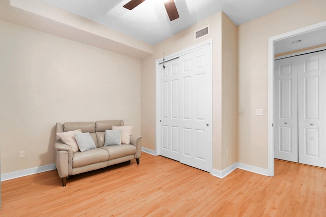 living area featuring ceiling fan and hardwood / wood-style floors