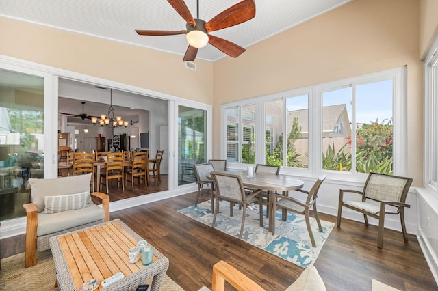 sunroom featuring ceiling fan with notable chandelier