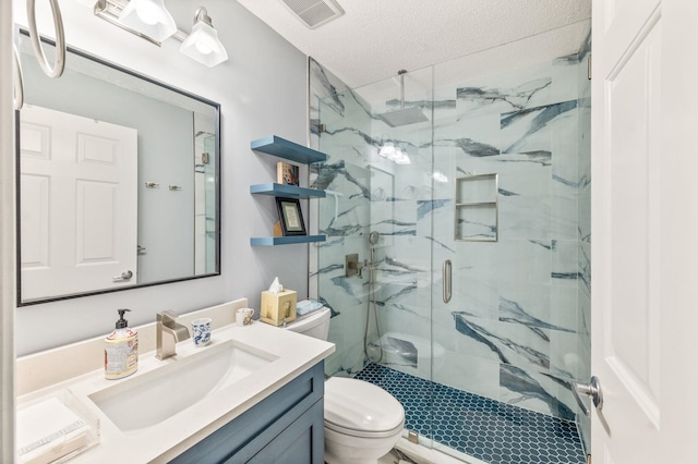 bathroom with vanity, toilet, a shower with shower door, and a textured ceiling