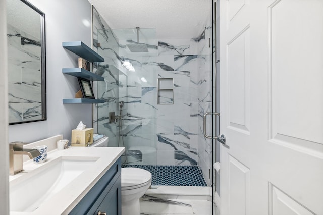 bathroom featuring vanity, toilet, a shower with shower door, and a textured ceiling