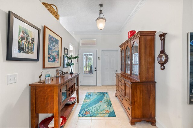 entrance foyer with crown molding, light tile patterned floors, and a textured ceiling