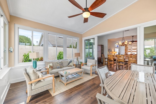 sunroom / solarium featuring a wealth of natural light, ceiling fan with notable chandelier, and lofted ceiling