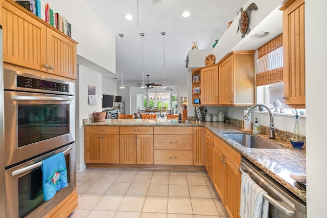 kitchen featuring sink, ceiling fan, light tile patterned floors, appliances with stainless steel finishes, and kitchen peninsula