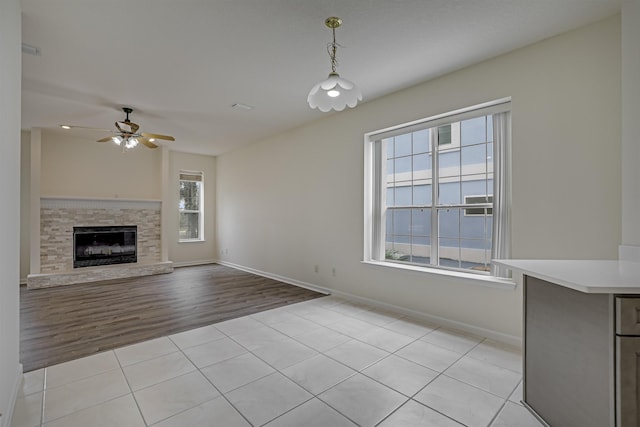 9162 August Cir, Saint Augustine, FL 32080 - unfurnished living room featuring ceiling fan, light tile patterned flooring, and a stone fireplace