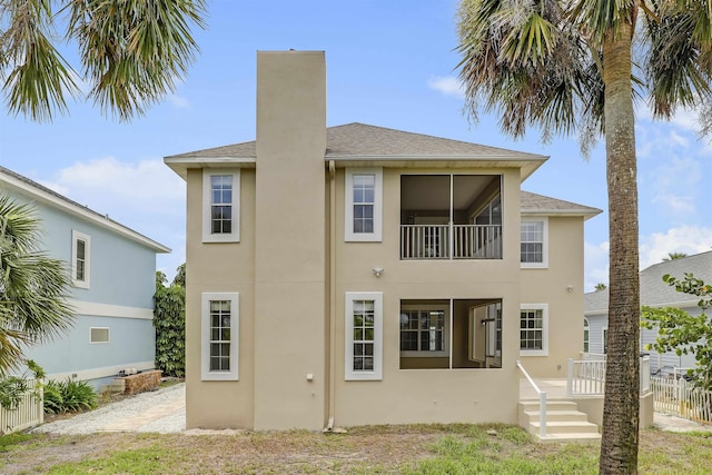 9162 August Cir, Saint Augustine, FL 32080 - back of property featuring stucco siding, a chimney, and roof with shingles