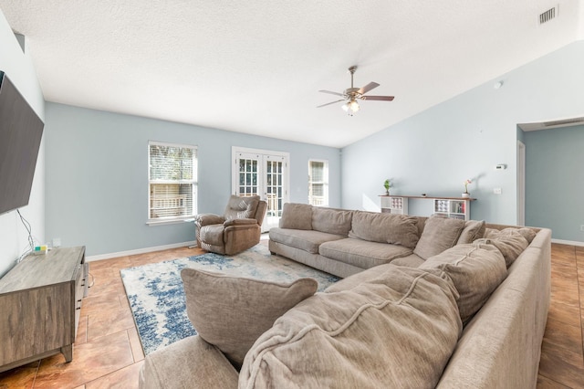 tiled living room featuring french doors, ceiling fan, vaulted ceiling, and a textured ceiling