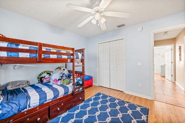 bedroom featuring ceiling fan, hardwood / wood-style floors, a closet, and a textured ceiling