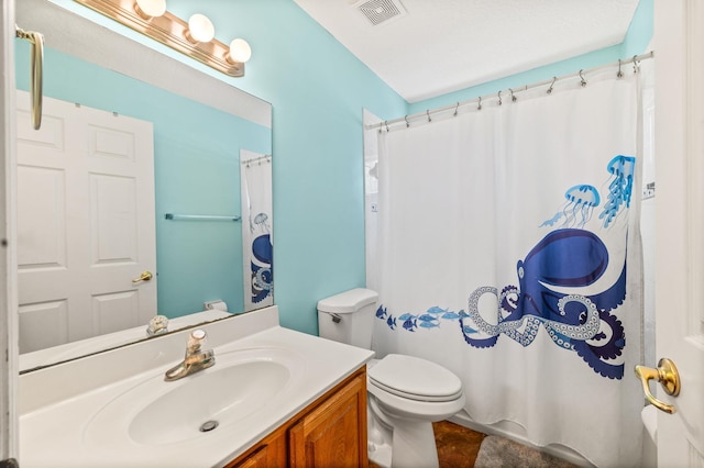 bathroom with vanity, curtained shower, and toilet