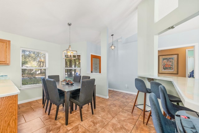 tiled dining room with vaulted ceiling and a chandelier