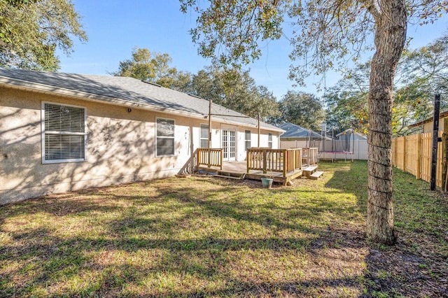 back of house featuring a deck and a lawn