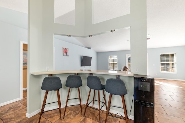 kitchen featuring light tile patterned flooring, a kitchen breakfast bar, and kitchen peninsula