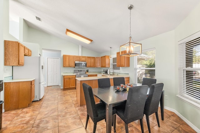 tiled dining space featuring vaulted ceiling and sink