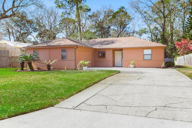 ranch-style home with an attached garage, fence, a front lawn, and concrete driveway